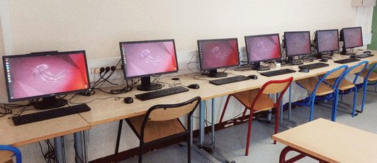 Photo de 7 PC sur Linux, avec le bureau affichant un fond violet permettant de reconnaître Ubuntu